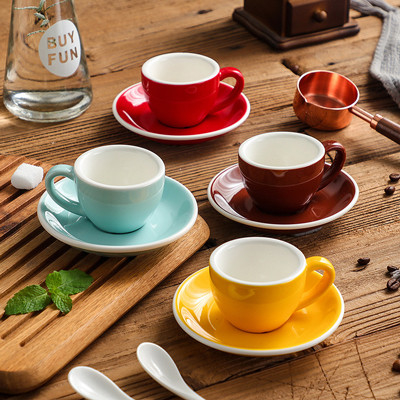 Les tasses multicolores d'expresso de la porcelaine 75ml avec des soucoupes entassent en vrac des approvisionnements de cuisine