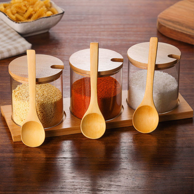 Les conteneurs de assaisonnement de condiment en verre entassent en vrac les pots réutilisables d'épice avec la cuillère en bois de couvercle